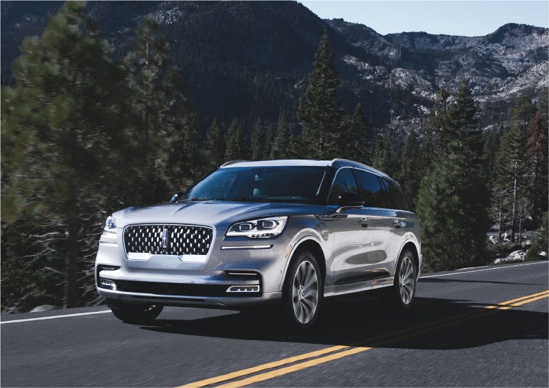 A 2023 Lincoln Aviator® Grand Touring SUV being driven on a winding road to demonstrate the capabilities of all-wheel drive | Vision Lincoln in Wahpeton ND